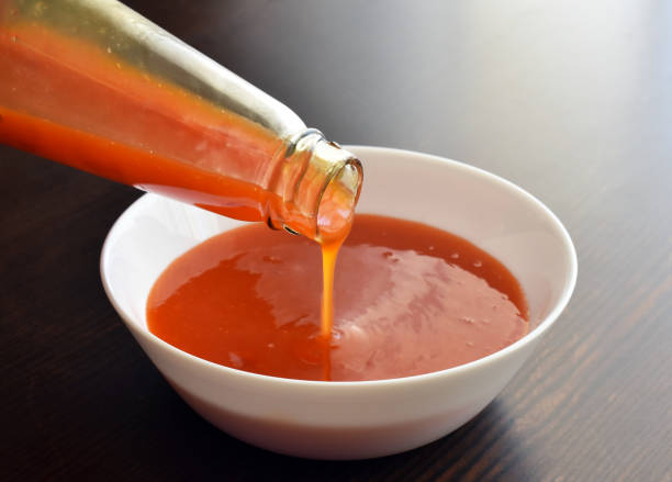 istock Sweet chilli sauce pouring into a white bowl. 1710172970