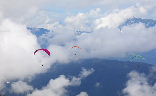 some paragliders even have two people flying at the same time in the clouds in the mountains in summer