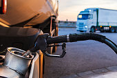 Diesel nozzle from a gas station filling a truck tank, close-up.