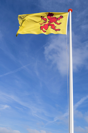 Sail boat mast with a waving Greek flag against a cloudless blue sky.