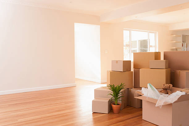 Boxes stacked on wooden floor of new house  unpacking stock pictures, royalty-free photos & images