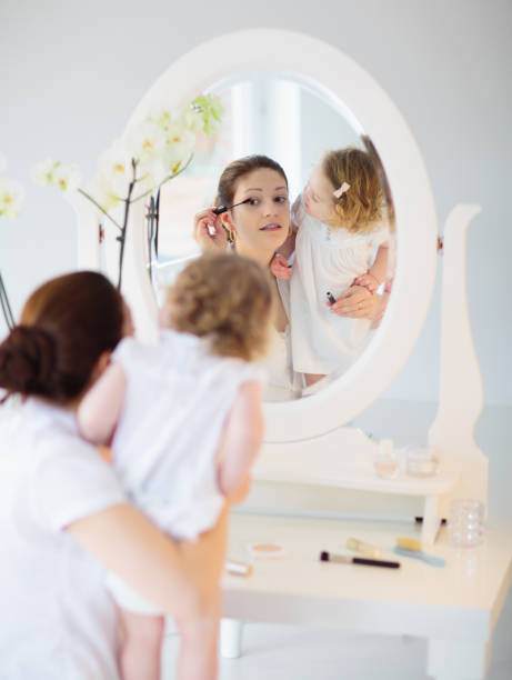 istock Mother and daughter looking in mirror 1710233794