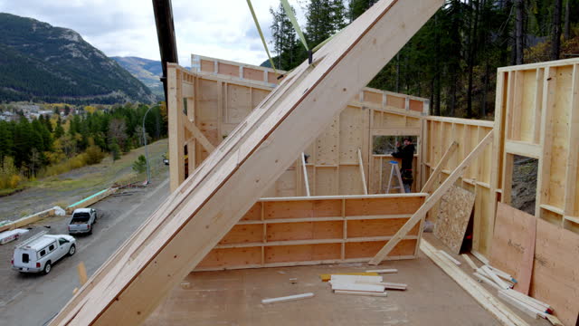 Men build home from scratch, erect large front wall
