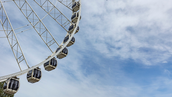 09/25/2023  Liverpool uk passenger cabins on modern metal Ferris wheel against blue sky in Amusement park. Popular tourist attraction