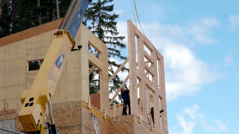 View of crane helping to  erect large front wall of home