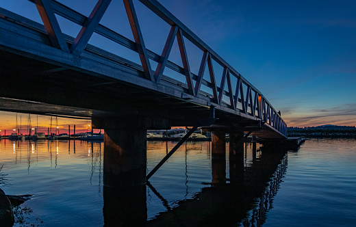 Wooden walkway. Bridge pier walk in sunset. Pier bridge at night time at West coast. Travel photo, nobody