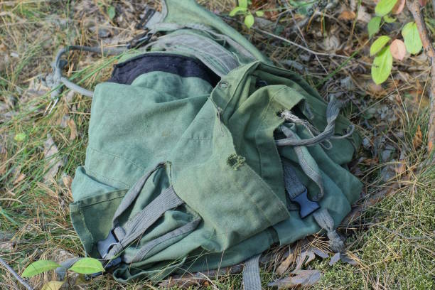 istock one crumpled green fabric backpack lies on the ground and grass 1710379823