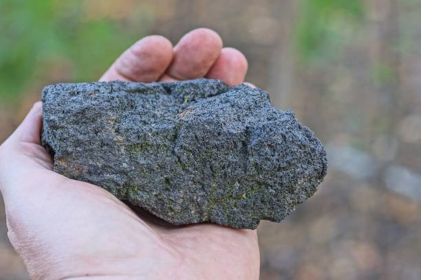 istock hand holding one large piece of black coal 1710383613