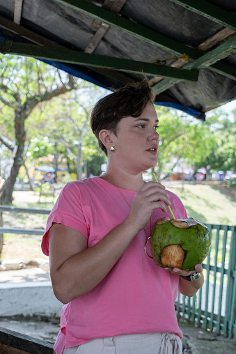 Olinda, Pernambuco, Brazil:Young woman drinking coconut water in Olinda.