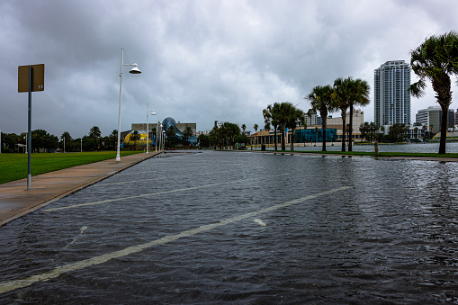 St. Petersburg, Florida, Tampa Bay, USA - August, 30, 2023: flooded parking lots at marina waterfront near airport in St. Petersburg, Florida. Hurricane hit the land and taking a break, but not over. Salvador Dali museum and high rise buildings on background. Hurricane aftermath