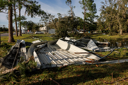 Post storm situation in small town: building destroyed, roof torn off. Debris strewn about in Perry, North Florida