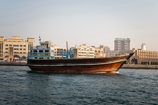 Arabian wooden traditional boat on the water in the river in the old Dubai area.