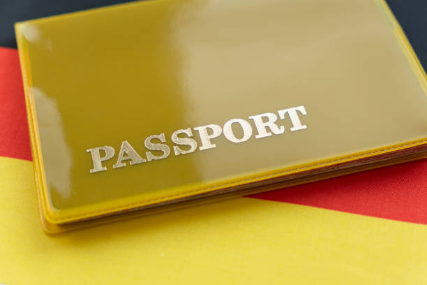 na brązowej powierzchni leży paszport, wewnątrz którego znajduje się flaga niemiec - customs emigration and immigration prevent entrance zdjęcia i obrazy z banku zdjęć