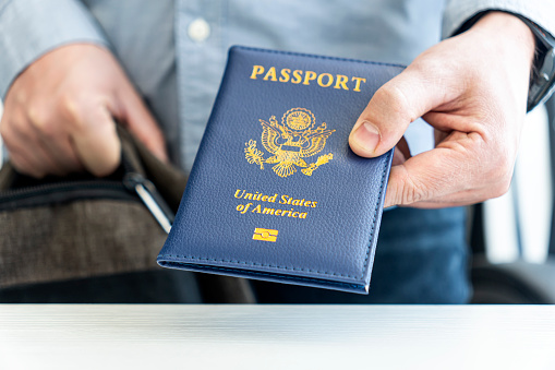 hand holding passport with bokeh background, jorney and travel concept. Passport check at the border. A man will find a passport for obtaining a visa at the airport.