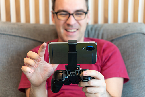 Hands with joystick with phone. a gamer plays on a smartphone