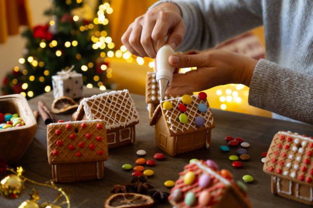 Woman is decorating gingerbread houses ready for Christmas