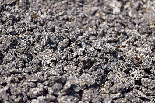 Pile of ground asphalt used to repair and maintain roads and paths in a small public park