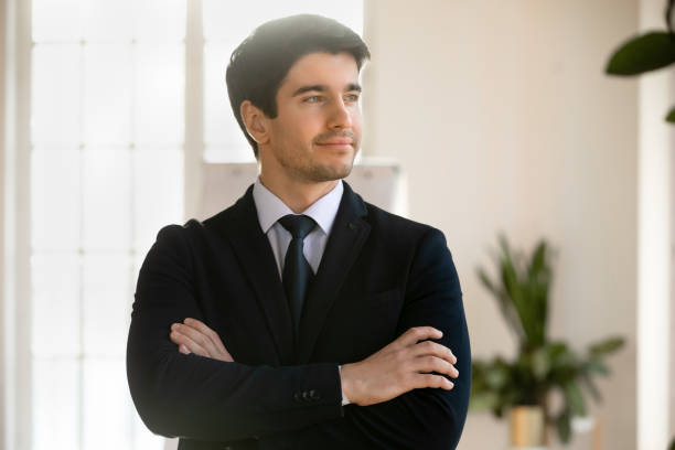 Young Caucasian businessman look in distance thinking