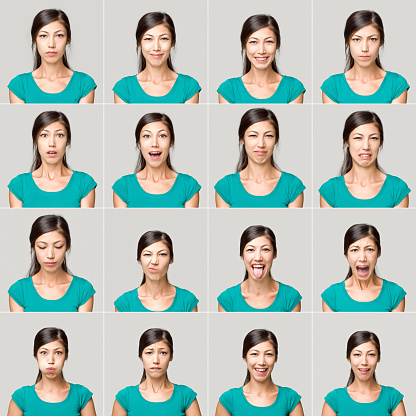 Pretty young woman making sixteen different facial expressions. All the images have been set against a light gray background. The young woman wearing a green t-shirt. Some of her expressions include happiness, anger, boredom, thoughtful and worry.