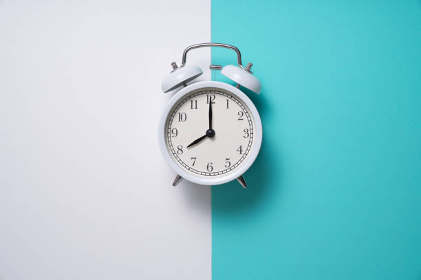 Retro alarm clock on green and white table background, vintage style, flat lay