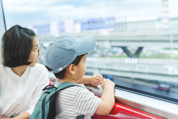 Asian mother and her son sitting in commuter train