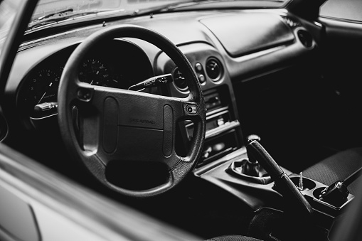 An interior view of a car, in grayscale