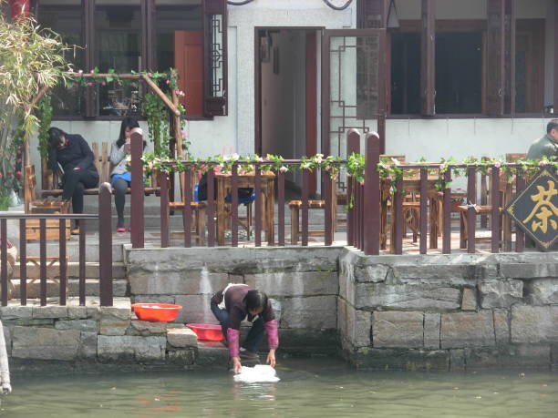 eine chinesin wusch geschirr in den kanälen der historischen wasserstadt xitang in der provinz zhejiang, china - zhejiang provinz stock-fotos und bilder