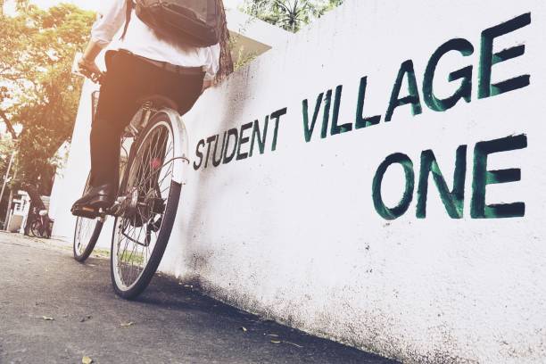 Student is riding bicycle in village green campus