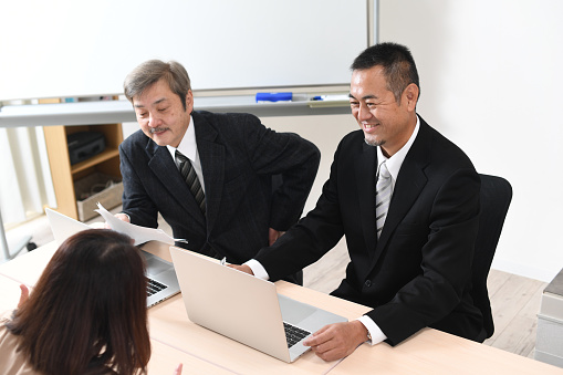 Asian middle-aged and elderly businessmen having a meeting at work