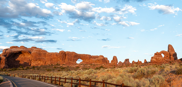 North Window (left) and Turret Arch (right) in the Windows section of Arches National Park, Utah, USA. Crowds of tourists scattered among the rocks.