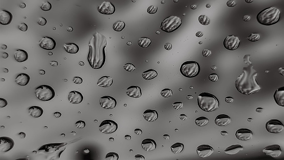 Close-up of cityscape with high rise buildings seen through wet glass window.