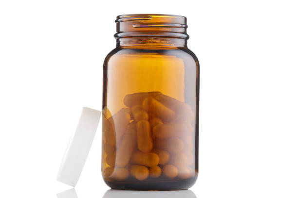 istock Open Brown dietary bottle with capsules, vitamins, pills, supplements isolated on white background 1710754632
