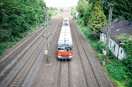 Cologne, Germany – August 14, 2019: An old train runs alone over the tracks. The picture is taken from a bridge and you can see the train head-on.