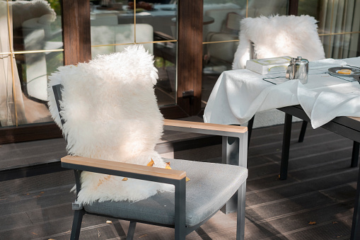 armchairs covered with sheep skins in a patio, outdoor autumn daylight shot