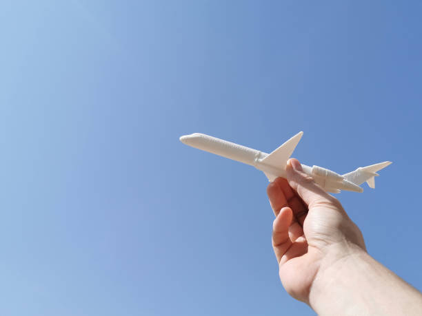 istock Man hand holding 3D printed airplane model with blue sky background. 1710832929