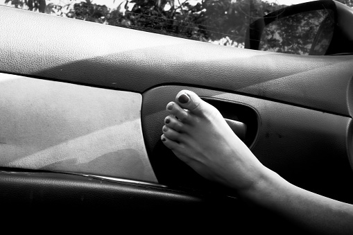 the woman's feet were in the open car door.