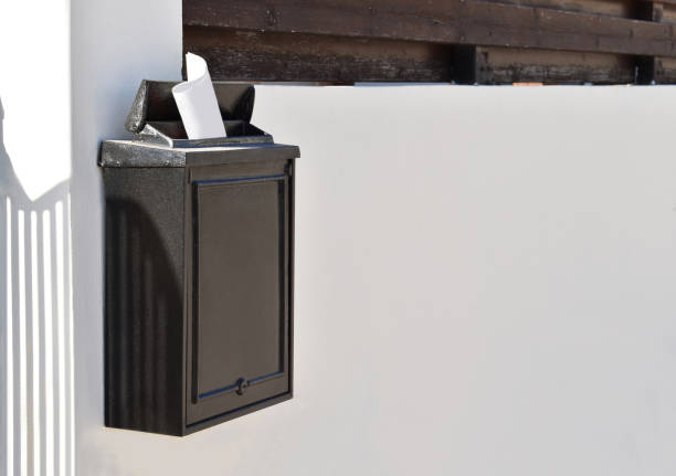 istock Black mailbox in front of a house with shadow and sunlight. 1710847632