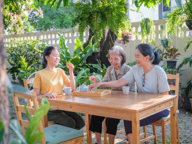 istock Asian multi generation family women enjoy talking and drinking afternoon tea while setting in the backyard at home 1710856326