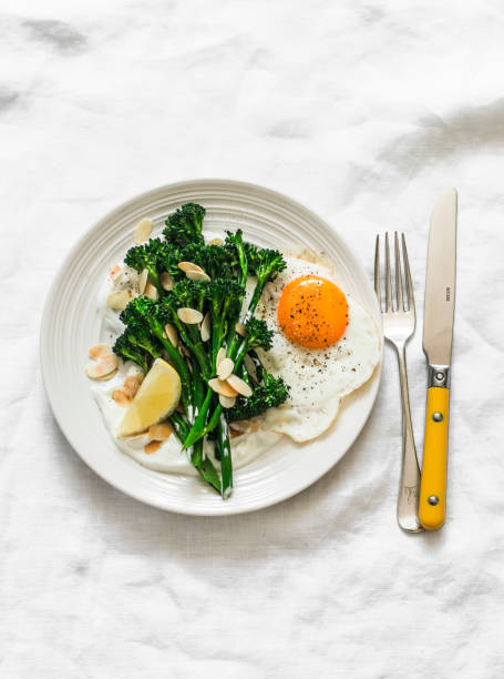 istock Grilled broccolini with greek yogurt and toasted almonds and fried egg on a light background. Delicious breakfast, brunch 1710866646