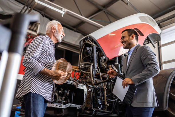 istock Farmer discussing about tractor repair at workshop. 1710867177