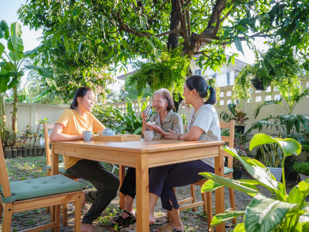istock Asian multi generation family women enjoy talking and drinking afternoon tea while setting in the backyard at home 1710871378