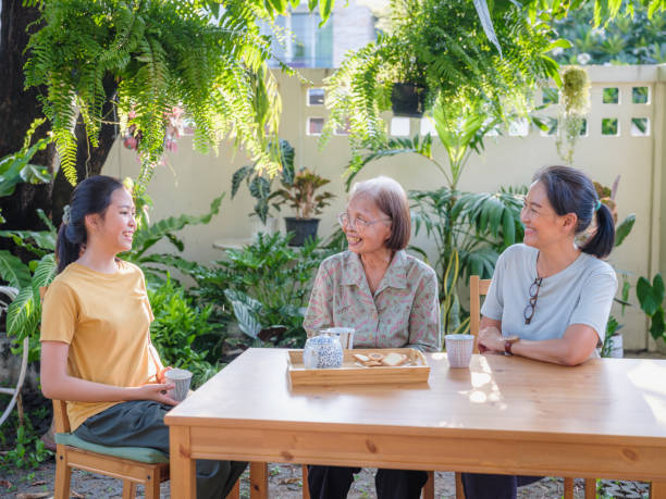 istock Asian multi generation family women enjoy talking and drinking afternoon tea while setting in the backyard at home 1710881831