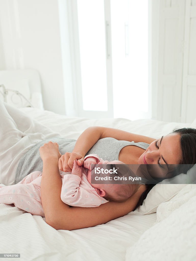 笑顔の母親と赤ちゃんベッドで味わう - 25-29歳のロイヤリティフリーストックフォト
