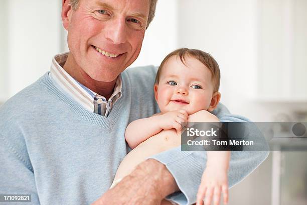 Sorridente Avô Segurando Bebê - Fotografias de stock e mais imagens de 6-11 meses - 6-11 meses, 60-64 anos, Abraçar