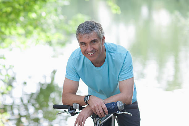 sorrindo o homem em pé com bicicleta - water bottle sports and fitness selective focus sport - fotografias e filmes do acervo