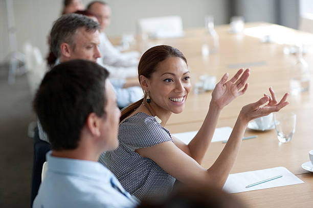Smiling businesswoman gesturing in meeting in conference room  persuasion photos stock pictures, royalty-free photos & images