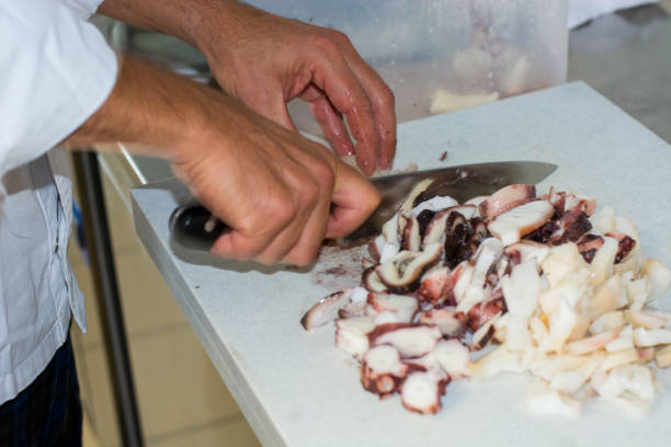 finely chopping the octopus just boiled in boiling water in Italian cuisine finely stock pictures, royalty-free photos & images