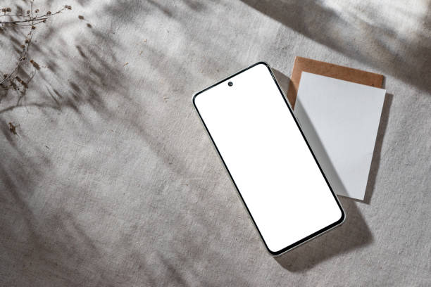istock Mobile phone with empty screen mock up on neutral beige linen background with aesthetic floral sun light shadow, minimalist business brand, social media blog template, copy space 1710971951