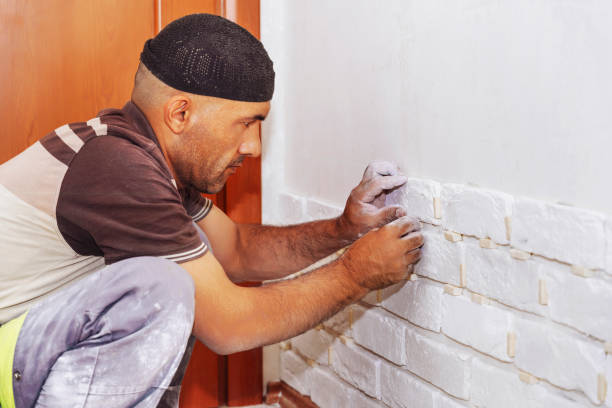 istock A man glues a white decorative  a brick to the wall 1710973567