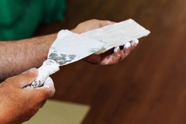 istock Hands man plasterer construction worker at work closeup, takes plaster and puts it on trowel to plaster the wall, inside the building site of a house 1710978592